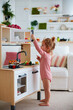 © Olesia Bilkei - cute toddler baby girl playing on toy kitchen at home