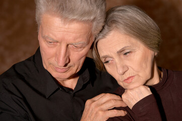 Portrait of sad senior couple posing at home