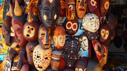 selection of african masks carved from wood and decorated, some with seashells and others by being e