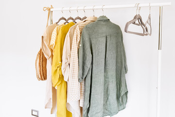 Linen clothes on gray hangers on the clothes rack. Slow Fashion. Conscious consumption. Crisis in the fashion industry, retail. Eco-friendly, Sustainable seasonal Sale concept. Zero waste.