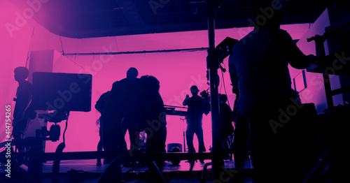 Behind the scenes of shooting video production and lighting set for filming movie which film crew team working in silhouette and professional equipment in studio for video online. video production con