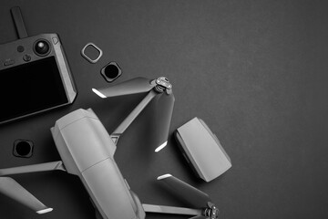 Wall Mural - modern drone with camera and video production equipment on black background, flat lay. space for tex