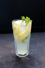 A close-up of glass of lemonade, drink, cocktail on a black stony background.