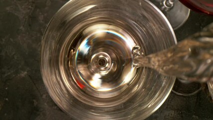 Wall Mural - Camera Movement, Super Slow Motion Detail Shot of Pouring White Wine from Bottle with Black Stone Background at 1000fps.