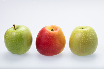 Green and red apples with water drops, isolated on white background