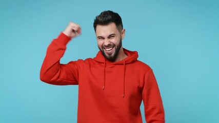 Wall Mural - Happy overjoyed young man 20s years old in red streetwear hoodie isolated on blue background studio. People lifestyle concept. Count countdown 1 2 3 one two three doing winner gesture clenching fists