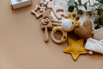 newborn baby accessory and wooden toys in a box on a brown background. top view, flat lay. baby show