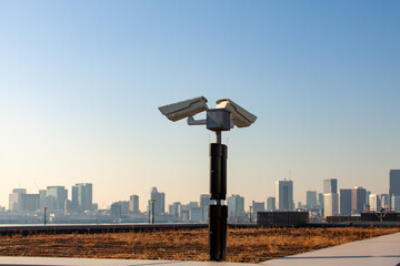 Wall Mural - CCTV cameras and surveillance security system faces Tokyo skyline