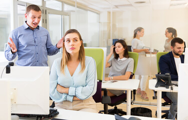 Wall Mural - Irritated boss scolding unhappy female subordinate pointing out shortcomings and misses in work