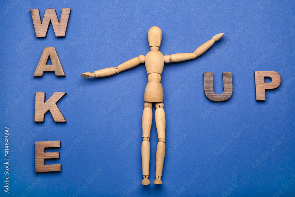 Wooden mannequin with words WAKE UP on color background