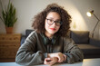 girl serious calm expression on her face in glasses is sitting at table at home. Video Conference or e-learning at home. portrait of person at wide angle. woman talks over Internet.