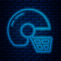 Sticker - Glowing neon line American football helmet icon isolated on brick wall background. Vector.