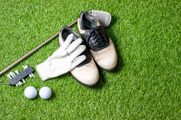 Wall Mural - Golf ball with golf shoes and glove on green grass