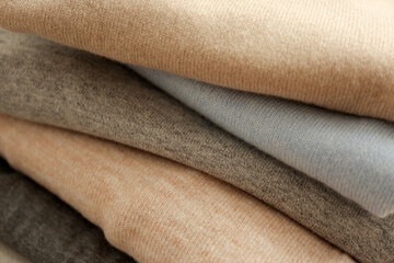 Stack of cashmere clothes as background, closeup