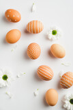 Fototapeta Mapy - Stylish Easter eggs and spring flowers on white background. Happy easter minimal concept. Flat lay, top view.