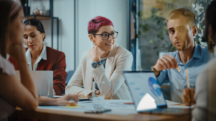 office meeting in conference room: beautiful specialist with short pink hair talks about firm strate