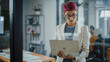 © Gorodenkoff - Modern Office: Portrait of Beautiful Authentic Specialist with Short Pink Hair Standing, Holding Laptop Computer, Concentrated on Her Work. Working on Design, Data Analysis, Plan Strategy