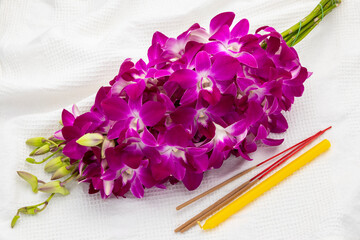 Orchid bouquet, a candle and three incense sticks, the set that Thai Buddhists popularly offer to monk, priest, Buddha image or Buddha statue.  This expresses Thai Buddhists’ respect to Buddhism.