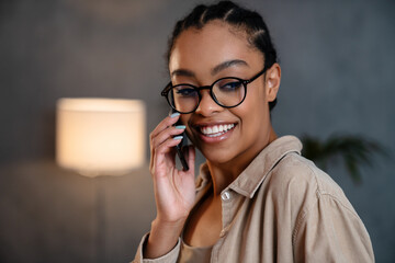 Wall Mural - Cheerful african american woman talking on mobile phone and smiling