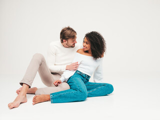 Smiling beautiful woman and her handsome boyfriend. Happy cheerful multiracial family having tender moments on grey background  in studio. Multiethnic models hugging. Embracing each other.Love concept