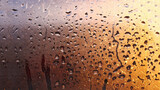 Fototapeta Tęcza - Horizontal natural background with water drops on the window with sunbeams, condensation on the glass with dripping drops