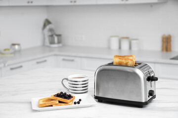 Canvas Print - Modern toaster and tasty breakfast on white marble table in kitchen