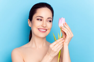 Wall Mural - Photo of attractive woman happy positive smile look tulips flower spa therapy isolated over blue color background