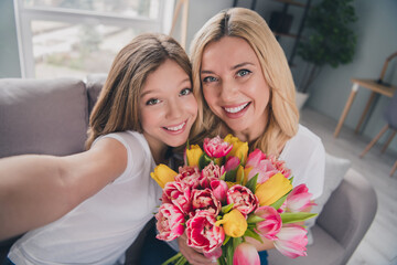 Canvas Print - Photo of blonde girl and woman make selfie camera hold flowers tulips indoors inside house apartment