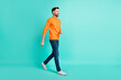 Full size profile side photo of young handsome cheerful good mood go walk travel isolated on teal color background