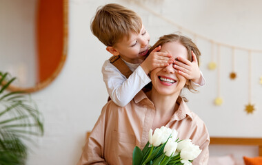 Wall Mural - tender son closes his mother's eyes, making her a surprise and gives her a bouquet of tulips, congra