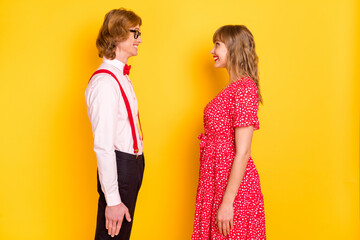 Sticker - Photo portrait of cheerful couple looking on each other on valentines day smiling happy isolated on vibrant yellow background