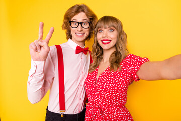 Sticker - Photo portrait of lovely couple taking selfie guy showing v-sign peace smiling isolated on bright yellow background