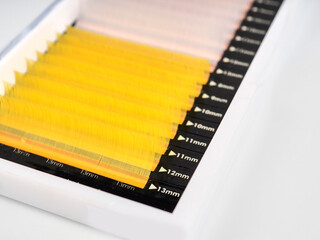 Multi-colored artificial eyelashes for extension, two colors in the macro palette, yellow and white.