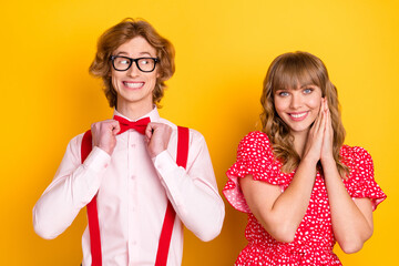 Sticker - Portrait of cheerful guy fix bow look interested adorable lady folded hands palms isolated on yellow color background