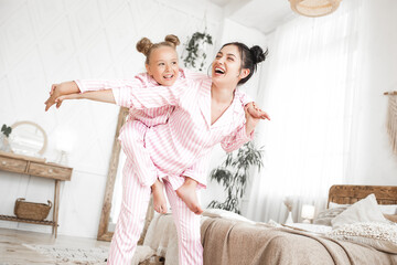 Mother and daughter having fun at home. Girls indoors.