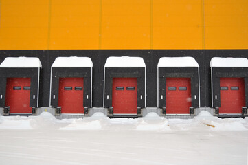 The empty loading bay of a large warehouse is covered with snow in winter.