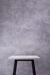 Poster - Table or metal stool with tabletop near concrete wall background