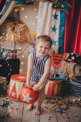 Wall Mural - A white boy lifts a circus weight. Stylized circus photo zone.