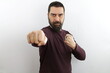 © Sandro Amato - Bearded man wearing casual shirt punching fist to fight, aggressive and angry attack, threat and violence.