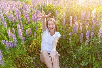 Happy girl smiling outdoor. Beautiful young brunete woman resting on summer field with blooming wild flowers green background. Free happy european woman. Positive human emotion facial expression.