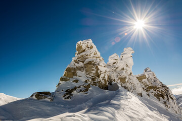 Poster - Low angle shot of sun rays falling on snow-covered mountains on a winter day