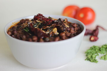 Wall Mural - Black chickpeas curry prepared by chickpeas cooked with onions, tomatoes and spices.