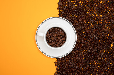 Top view of coffee cup with many coffee beans on the one side and on the other side yellow background for copy space