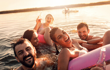 Wall Mural - Friends enjoying a summer day swimming at the lake.