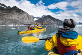 Fototapeta Miasta - Group of friends enjoy ocean kayaking bear glacier during their vacation trip to in Alaska, USA