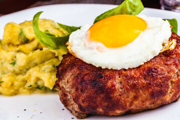 Wall Mural - Grilled steak with fried egg and mashed potatoes on white plate