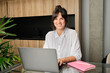 © Antonio Ovejero Diaz/Westend61 - Portrait of young woman working on laptop at home