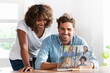 © steve brookland/Westend61 - Couple talking with friends on video conference over transparent screen at home