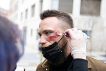 Close-up Of An Unrecognizable Makeup Artist Putting Makeup On A Hipster Man's Face