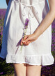 © Marianna Jaszczuk/ADDICTIVE STOCK - Back view of cropped unrecognizable peaceful young female in white summer dress standing in picturesque aromatic lavender field against cloudless blue sky in sunlight